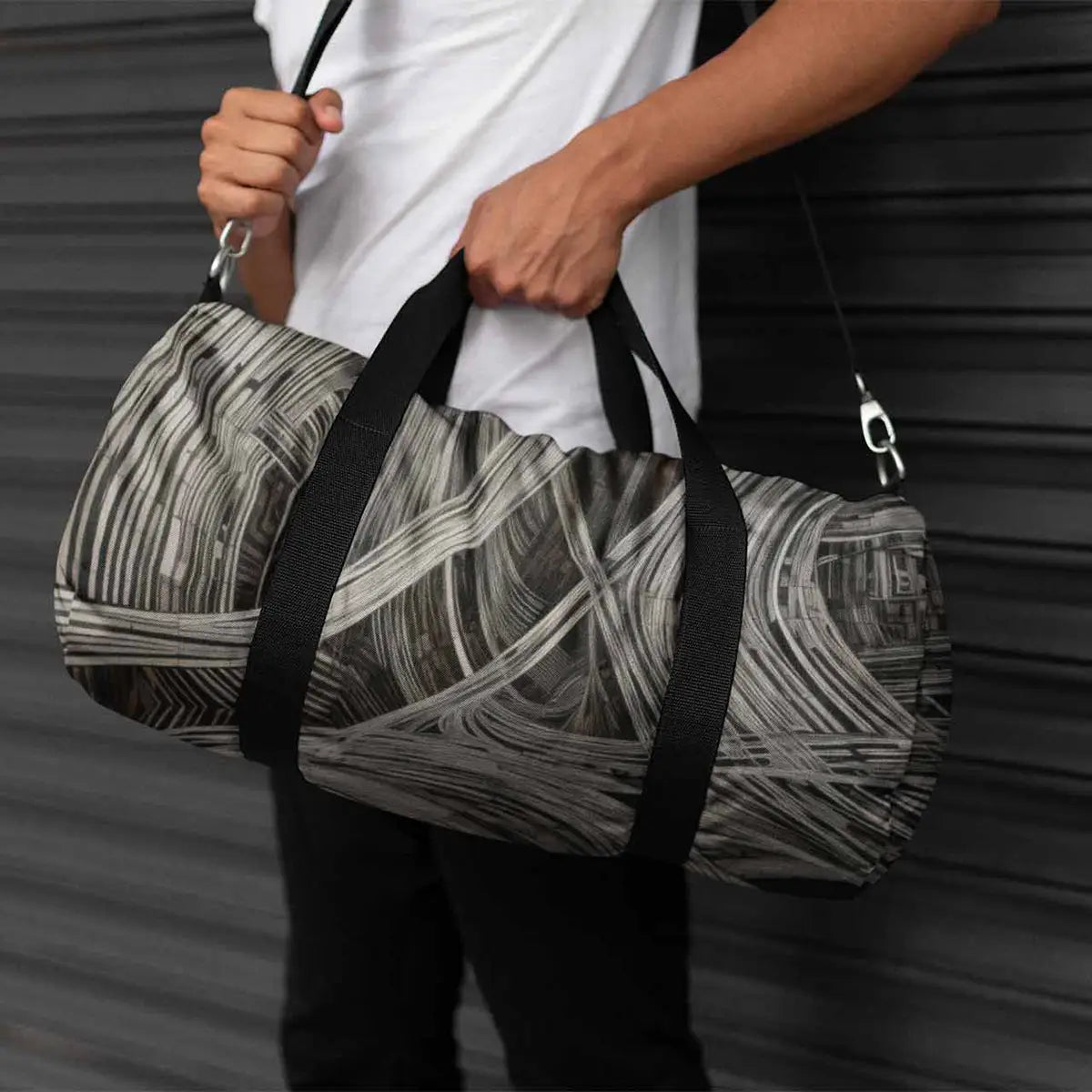 ADA-V digital art print mockup on a kit bag held by a man, showcasing bold geometric patterns in black and white.