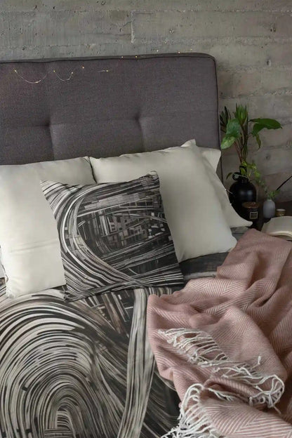ADA-V digital art print mockup featuring a duvet and pillow set on a tidy bed home design, showcasing bold geometric patterns in black and white.