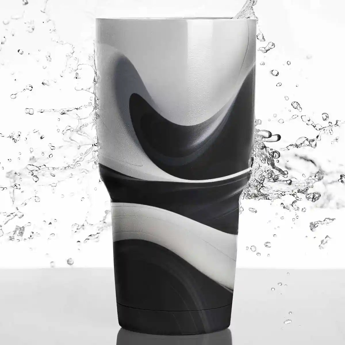 BW Ebb art print on a travel mug with water splashing in the background.