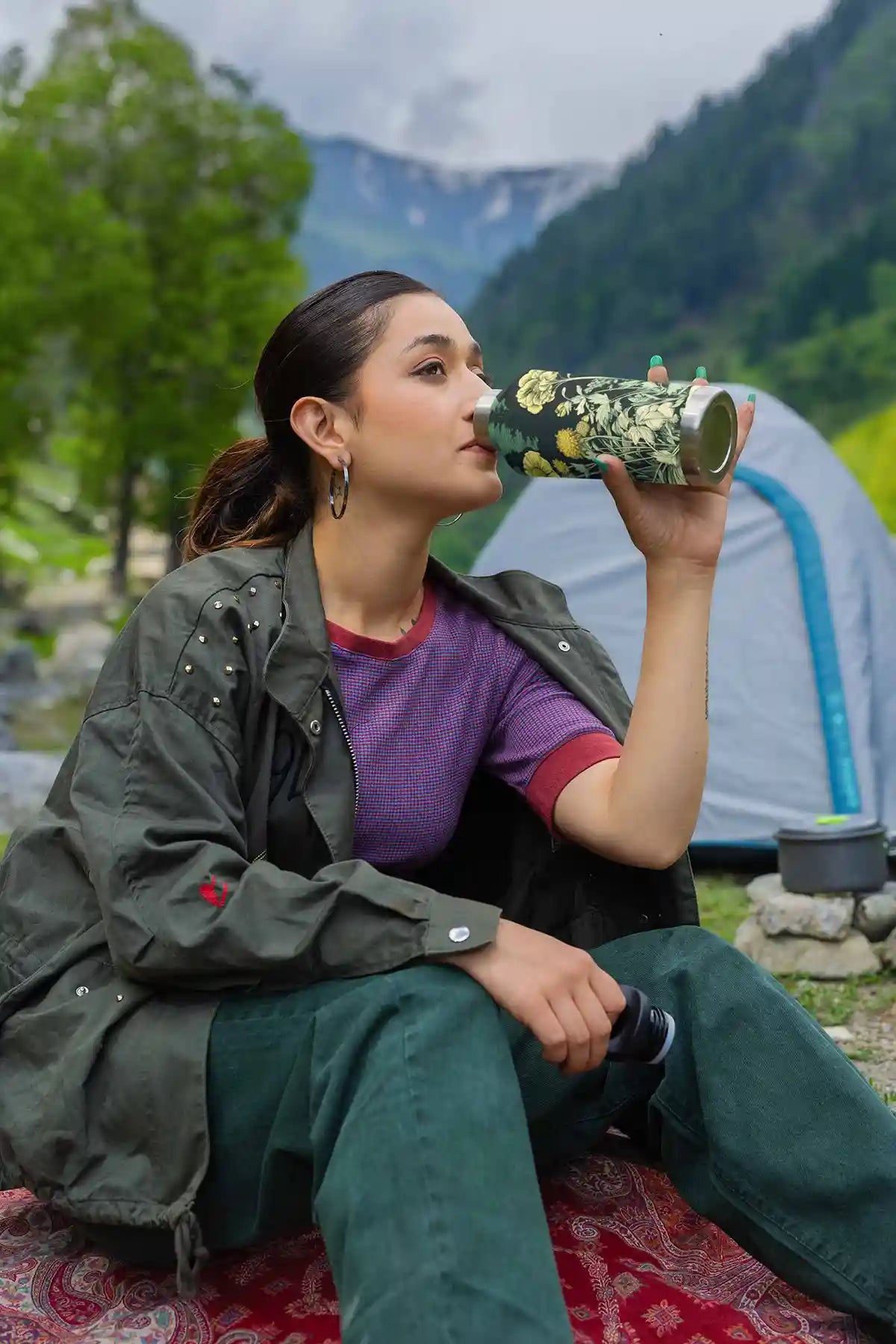 Lakeside Gem digital art print on a travel mug featuring a woman drinking water in the mountains.
