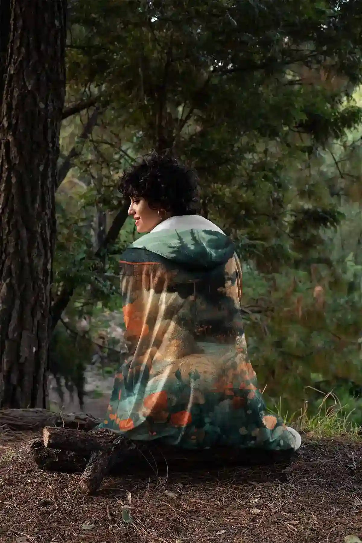 Memo digital art print on a hooded fleece blanket featuring a woman in the woods facing backwards, perfect for adding an artistic touch to home decor.