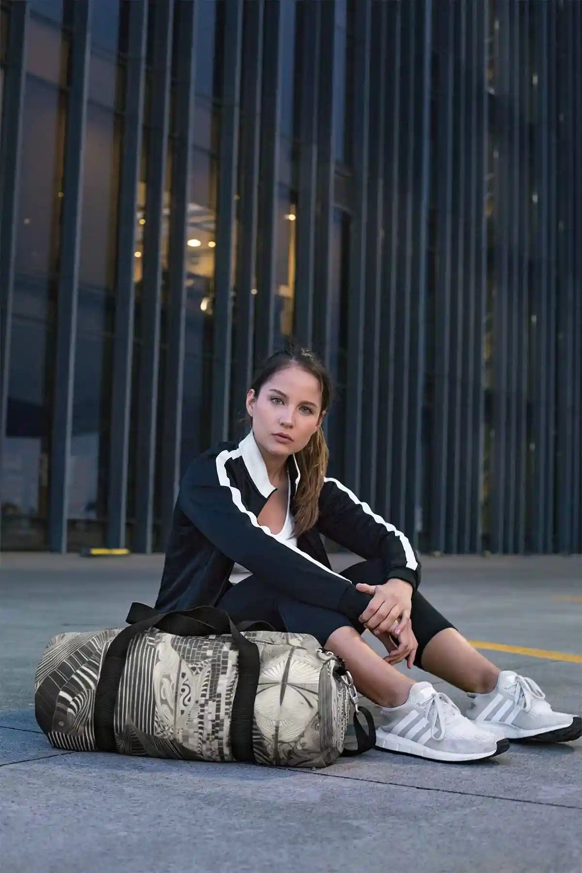 Monoka-5 digital art print on a duffle bag, featuring a serious young woman, showcasing abstract geometric design.