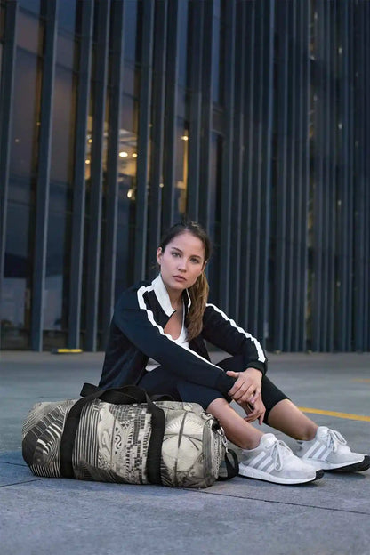Monoka-5 digital art print on a duffle bag, featuring a serious young woman, showcasing abstract geometric design.