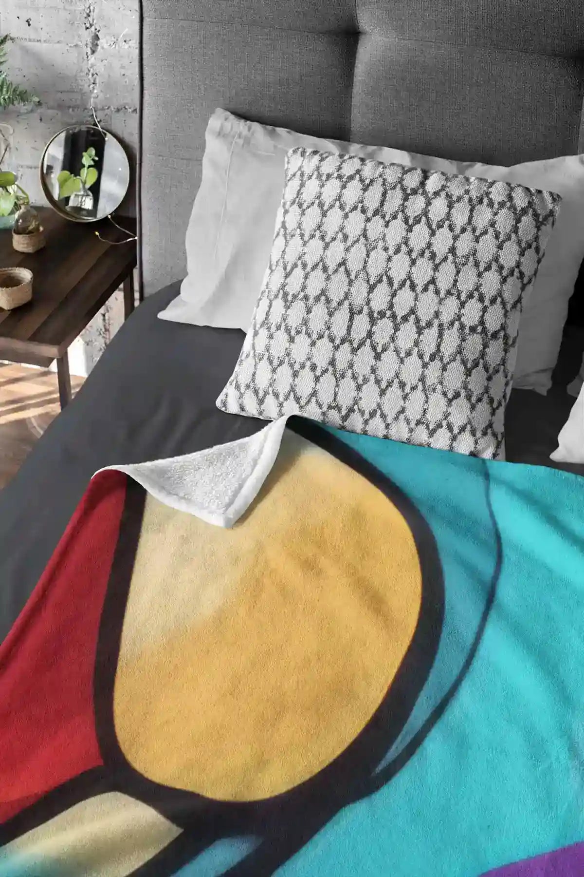 Multivue digital art print on a fleece blanket laid flat on a bed, showcasing vibrant abstract art with dynamic shapes.