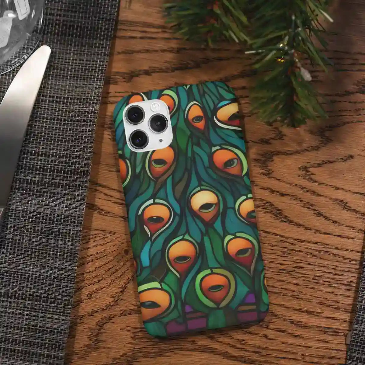 Peacock 1 digital art print on a phone case placed on a dining table, showcasing a vibrant stained glass peacock contemporary art
