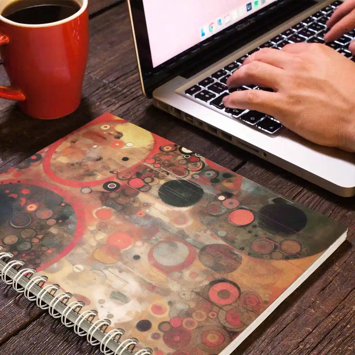 Sacred Serenade digital art print on a spiral school notebook lying near a laptop and a coffee mug.