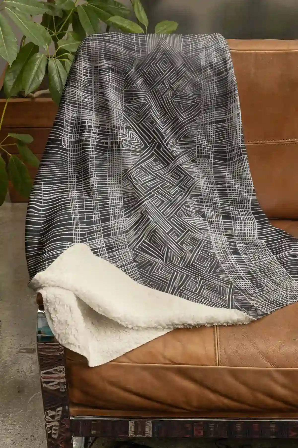 Soulprint digital art print on a Sherpa fleece blanket placed on a couch, featuring intricate geometric patterns and abstract art, adding a stylish and modern touch to the living space.